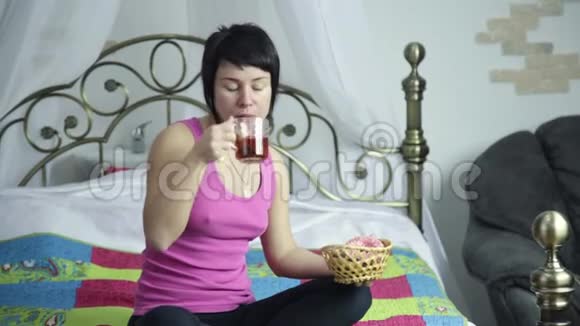运动女孩在床上快乐地吃甜甜圈禁止吃垃圾食品视频的预览图