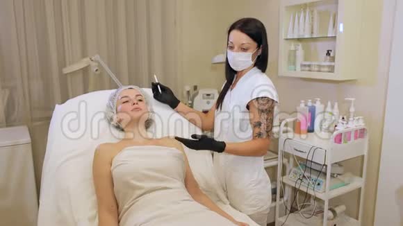 美容师在病人脸上画一支白色铅笔的轮廓视频的预览图