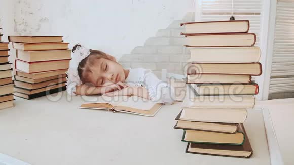 穿着校服的小女孩在看书的时候睡着了视频的预览图