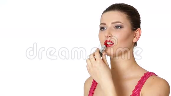 女人在白色背景上的嘴唇上涂红色口红视频的预览图