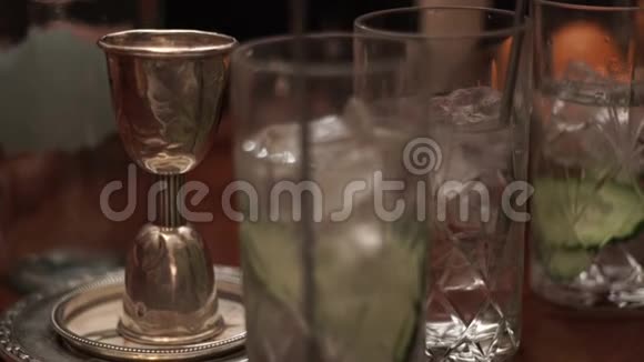 一杯糖浆和一杯鸡尾酒一起滴在杯子里酒吧鸡尾酒准备视频的预览图
