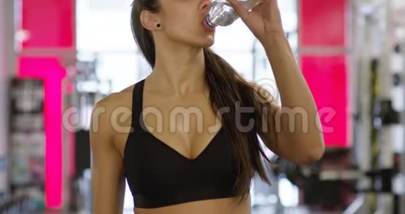 健身馆里有健康的身体饮料水的微笑女人视频的预览图