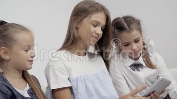 人孩子技术朋友友谊的概念快乐的三个小女孩与平板电脑电脑坐在一起视频的预览图
