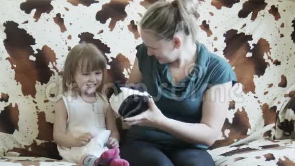沙发上戴着VR护目镜的女孩和母亲视频的预览图