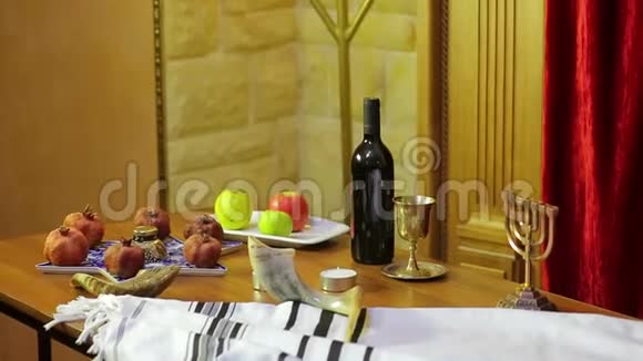 会堂的桌子上摆着罗什哈珊的标志塔利斯旁边有圣物和蜡烛视频的预览图