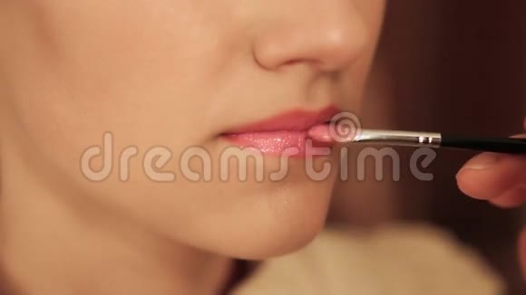 这女孩是一位化妆大师她把嘴唇涂在模特儿上视频的预览图