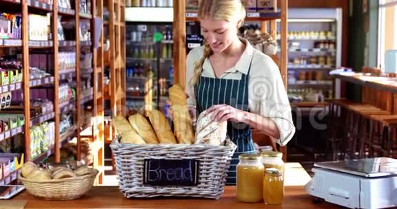 微笑的女员工在面包柜台检查面包视频的预览图