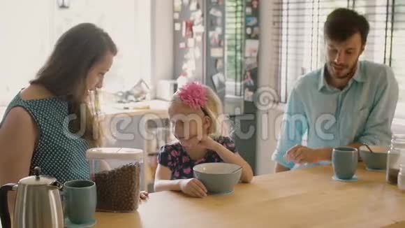 一个可爱的金发女儿在早餐时在她母亲耳边低语什么慢动作斯蒂达康射中视频的预览图