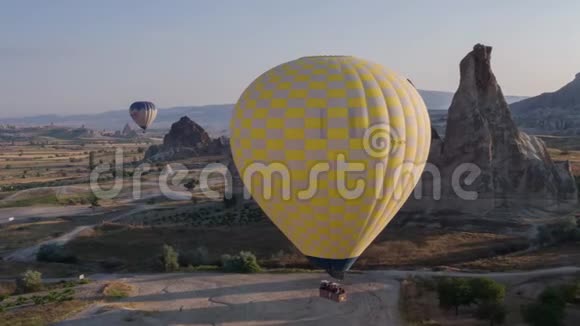 一个黄色的大气球的跨度在一个人的篮子里特写飞越群山卡帕多西亚全景视频的预览图