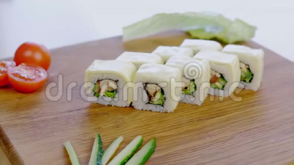 加鸡肉黄瓜青菜和奶油奶酪的卷放在木板上配蔬菜视频的预览图