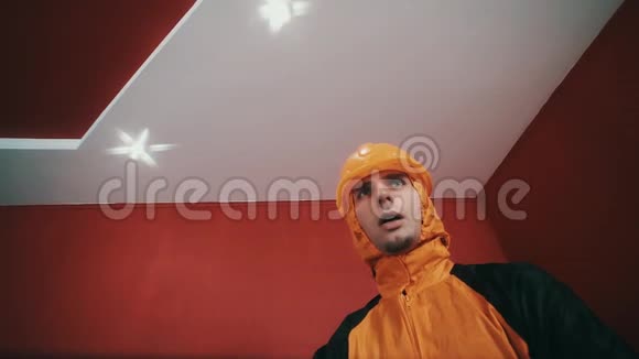 穿着危险夹克和橙色安全帽的家伙在红色的房间里武装起来说唱视频的预览图
