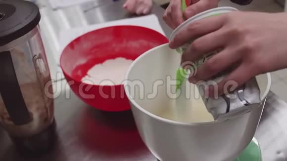 糖果女人的手把酸奶油放进厨房的搅拌碗里视频的预览图