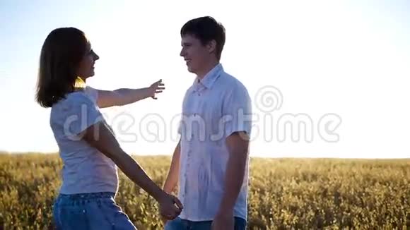 快乐的男孩和女孩温柔地拥抱在田野里视频的预览图