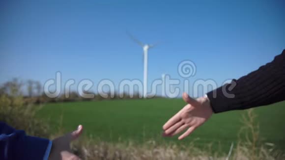 与风力涡轮机进行商务握手视频的预览图