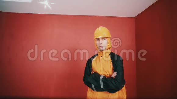 穿着危险夹克和橙色安全帽的人在红色的房间里武装起来说唱视频的预览图