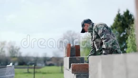 一个年轻的男建筑工人提出了砖的解决方案视频的预览图