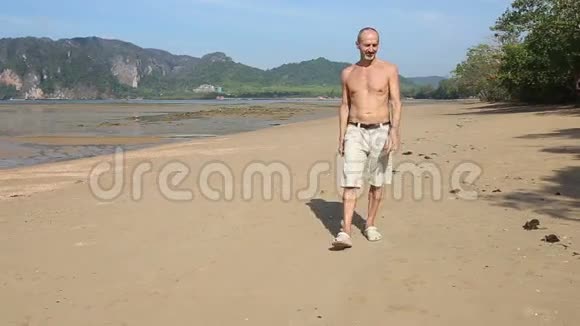 老人沿着海滩走视频的预览图