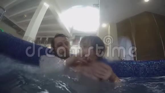 爸爸和小儿子在室内游泳池游泳视频的预览图