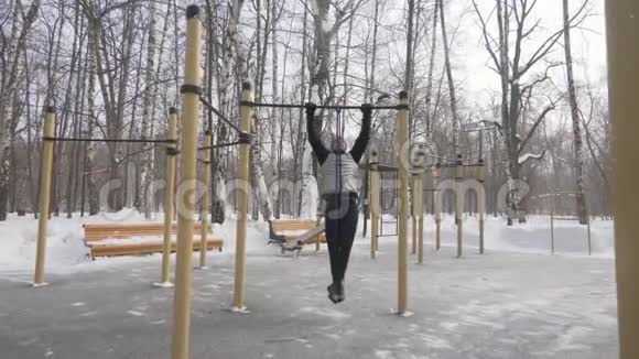 健身男子训练在运动场上拉起来锻炼户外冬季训练视频的预览图