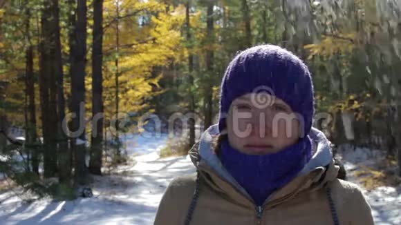 冬天的森林里雪从树上飘落到女孩的头上视频的预览图