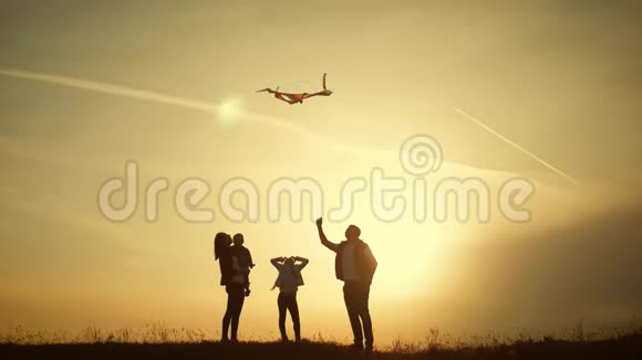 快乐的一家人在草地上玩风筝日落在夏日有趣的家庭时光快乐小女孩推出视频的预览图