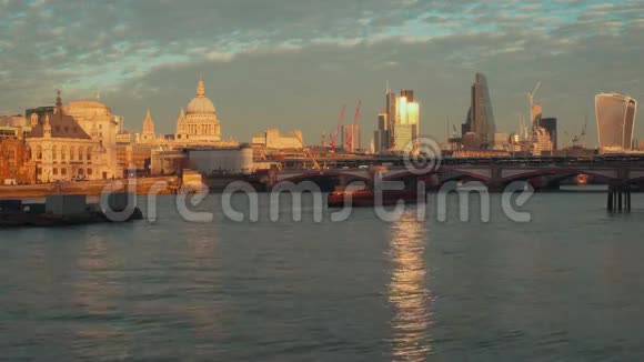 从泰晤士河堤上可以看到伦敦城布莱克弗里尔斯桥和圣保罗大教堂带着耀眼的光芒视频的预览图