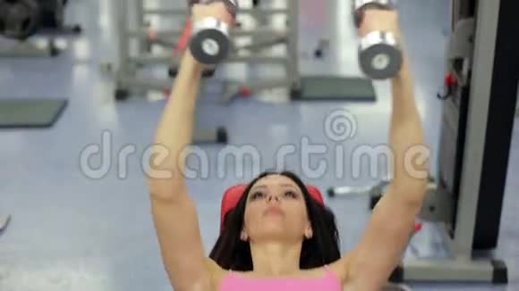 那个年轻的女人在健身房里摇动她的肌肉视频的预览图
