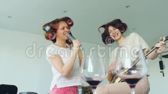 两个滑稽女孩用梳子缓慢地唱歌用电吉他跳舞唱歌视频的预览图