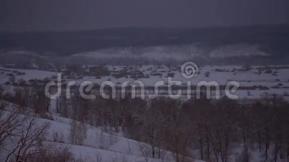 以雪覆盖的斜坡和冰冻的河流观赏冬季景观视频的预览图