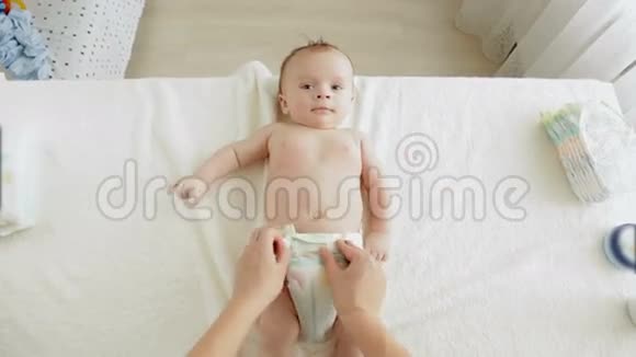 婴儿潮一代的年轻妈妈拿着脏尿布躺在桌子上视频的预览图