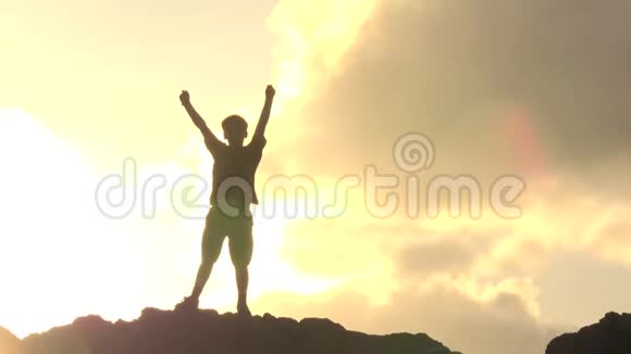日落时分站在大石头上的男孩视频的预览图