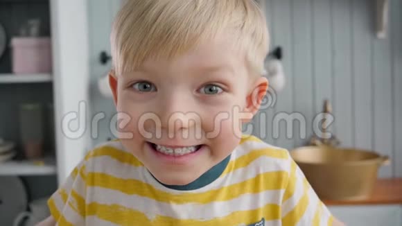 早晨在现代厨房背景下快乐的小男孩画像视频的预览图