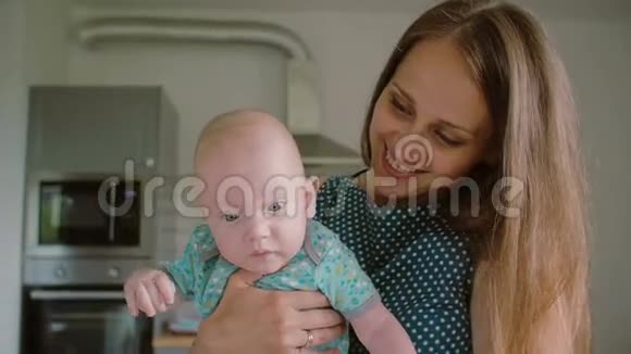 当她抱着她可爱的孩子面对镜头时一张年轻母亲的脸慢点斯泰迪达姆视频的预览图