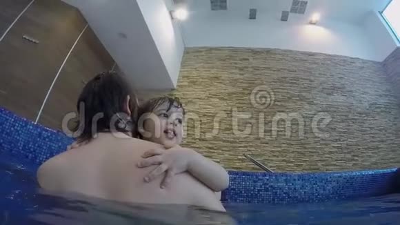 爸爸和小儿子在室内游泳池游泳视频的预览图