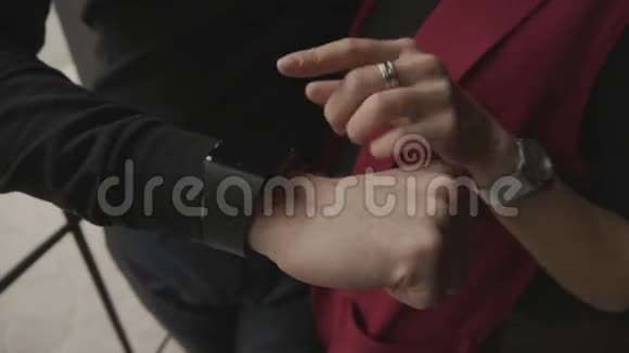 这对年轻夫妇在智能手表上查看信息他们的手被近距离射击视频的预览图
