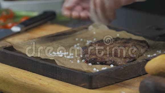 厨师用胡椒和盐处理牛排视频的预览图