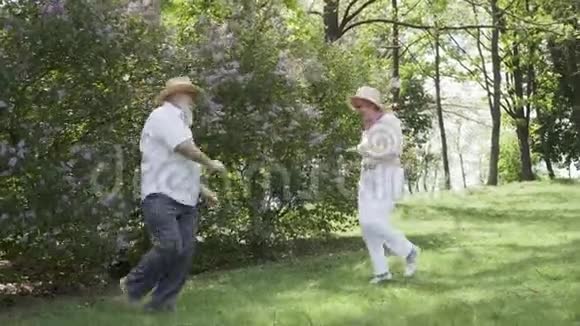 快乐相爱的老夫妻在夏日公园跳舞视频的预览图