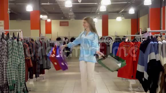 年轻的西班牙裔快乐女人带着购物袋到处转视频的预览图