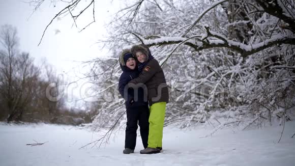 快乐有趣的孩子们站在下雪的树下两个人微笑着真的很开心这就是视频的预览图