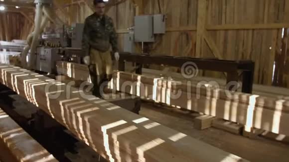 木工把木板放在木材厂的连接机上视频的预览图