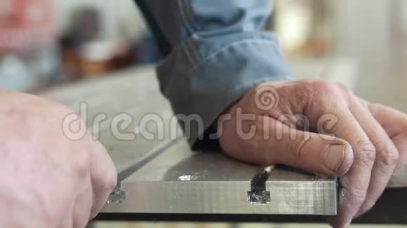 用刮刀制造数控机械的男性手倒角去除金属细节上的毛刺视频的预览图