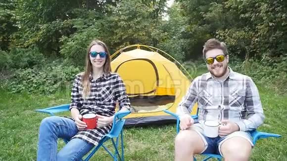 徒步旅行时一对年轻的幸福夫妇坐在帐篷里视频的预览图