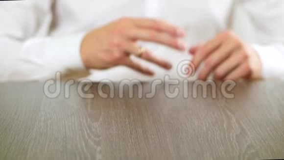 一个穿白色衬衫的人从手指上摘下订婚戒指关于离婚的决定视频的预览图