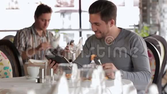 男性在午餐时使用平板电脑视频的预览图
