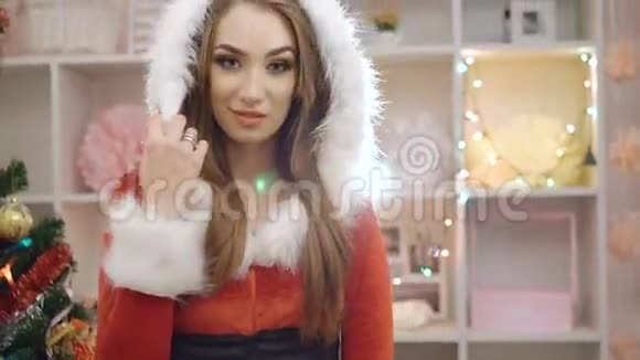 穿着圣诞服装的魅力女孩在4K的装饰品附近摆姿势调情视频的预览图