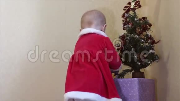 小孩站在圣诞树旁看礼物视频的预览图