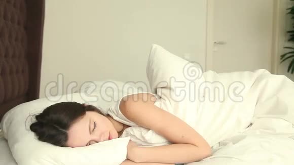 年轻女人睡在不舒服的床上视频的预览图