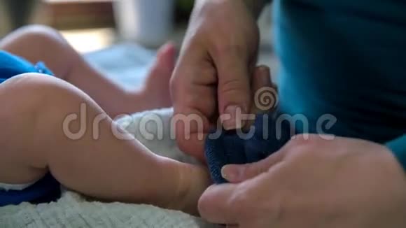妈妈把袜子放在婴儿的脚上视频的预览图
