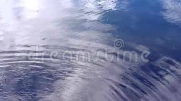 抽象的背景水反射天空中的云枝和水面上的树木视频的预览图
