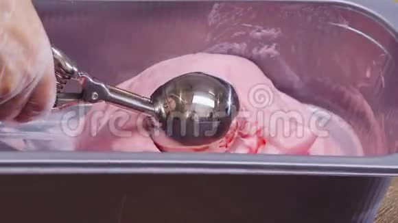 用勺子舀出的粉红色水果冰淇淋球视频的预览图